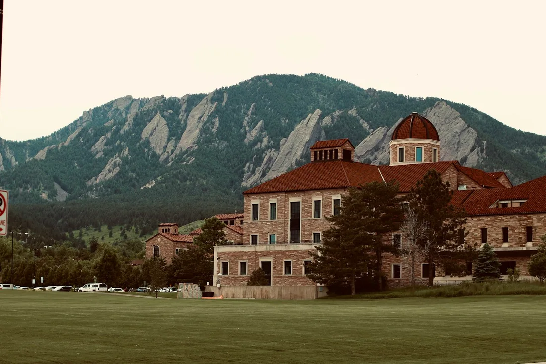 CU Boulder campus building with the Flatirons behind it